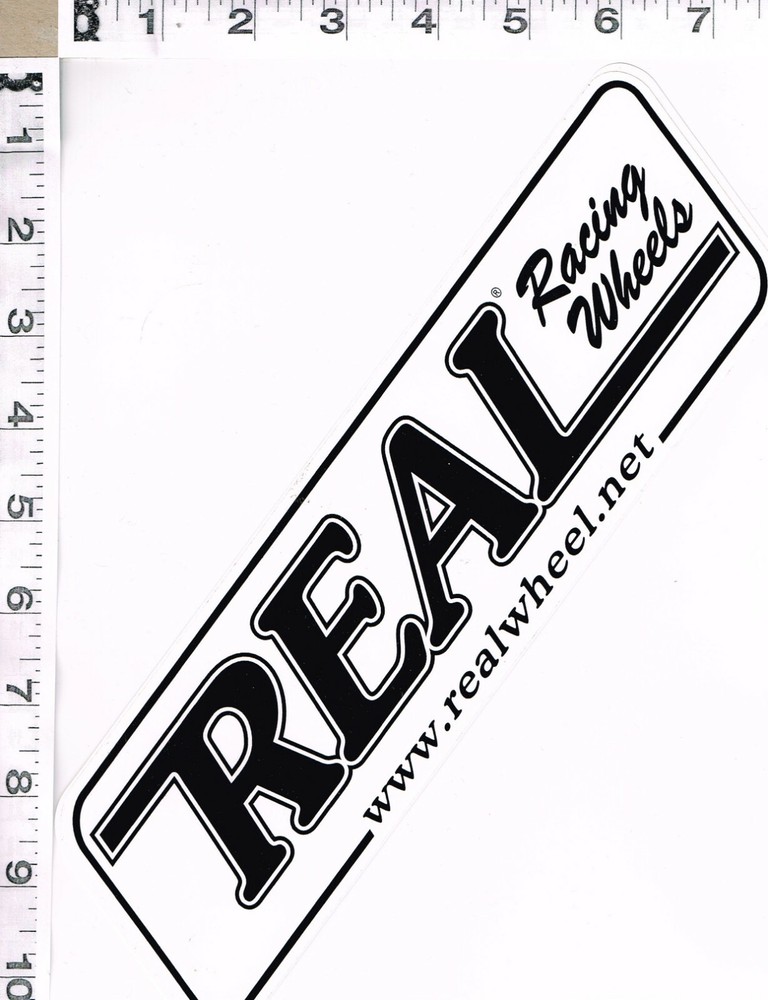 NEW, REAL RACING WHEELS STICKER, 11″ X 3″, BLACK WRITING ON WHITE BACKGROUND