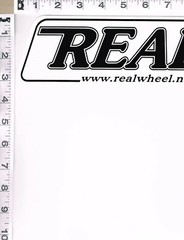 NEW, REAL RACING WHEELS STICKER, 11″ X 3″, BLACK WRITING ON WHITE BACKGROUND